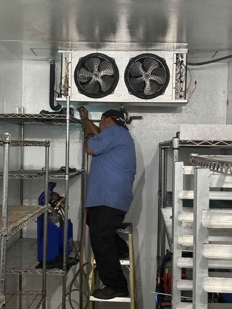 East Bay Refrigeration technician repairing refrigerant lines at a walk-in cooler evaporator